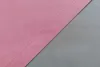 A close-up view of two pieces of fabric, one pink and one gray, joined by a seam. Produktbild-Vorschau