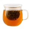 A glass mug filled with tea and tea leaves, with a lid. Náhled obrázku produktu
