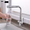 A hand is filling a glass with water from a modern kitchen faucet. Produktbild-Vorschau