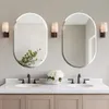 A modern bathroom vanity with two oval mirrors, sinks, and faucets. Voir les images du produit