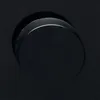 A close-up view of a black rotary dial on a black surface. Voir les images du produit