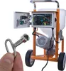 A hand holds a tool in front of a plastering machine. Anteprima dell’immagine prodotto