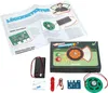 A lie detector kit is laid out on a white background, with instructions and components visible. Produktbild-Vorschau