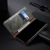 A smartphone case with cards and cash inserted, placed on a dark surface. Produktbild-Vorschau