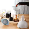 A set of kitchen funnels and a glass bottle with liquid being poured into it. Produktbild-Vorschau