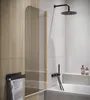 A modern bathroom with a bathtub, shower, and wooden accents. Anteprima dell’immagine prodotto