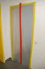 A doorway covered with a clear plastic sheet and sealed with yellow tape, with a red zipper running down the middle. Produktbild-Vorschau