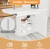 A white oval dining table with storage underneath, featuring an open cabinet with shelves and items inside. Icons and text are overlaid at the bottom and top. Náhled obrázku produktu