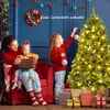 A family decorating a Christmas tree indoors. Náhľad obrázku produktu