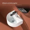 A white ceramic corner sink with a chrome faucet is shown with water swirling down the drain. The background is a textured brown wall. Anteprima dell’immagine prodotto