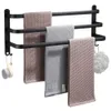 A black aluminum towel rack with three bars, holding three folded towels and a bath puff. Voir les images du produit