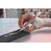 A hand is using a white marker to write on a dark metal bar. Produktbild-Vorschau