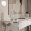 A close-up view of a white, glossy vanity table with decorative items. Produktbild-Vorschau