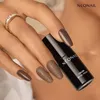 A hand with brown nail polish is holding a bottle of nail polish. Produktbild-Vorschau