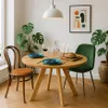 A dining table set for two in a well-lit room with plants and artwork. Produktbild-Vorschau