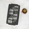 An ice cube tray with eight large ice cubes and a glass of iced beverage. Náhled obrázku produktu