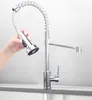 A hand is holding a pull-down faucet head, demonstrating its functionality, with the faucet base visible in the foreground. Produktbild-Vorschau