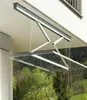 A retractable clothes drying rack is mounted under a balcony, with trees and foliage visible in the background. Anteprima dell’immagine prodotto