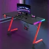 A gaming desk setup with a computer monitor, keyboard, mouse, and headphones, illuminated by RGB lighting. Produktbild-Vorschau