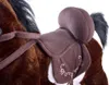 Close-up of a brown plush horse toy with a saddle. Voir les images du produit