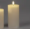 Two cream-colored LED candles with ribbed texture are shown against a plain gray background. The candle in the foreground has a lit LED flame. Produktbild-Vorschau