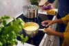Two people are cooking in a modern kitchen with an induction cooktop. Voir les images du produit