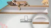 A dog sleeping on a carpeted shelf with a brush illustration below. Náhled obrázku produktu