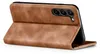 A brown leather flip case for a smartphone is shown from the side, with the front cover open and propped up. Produktbild-Vorschau