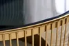A close-up view of the edge of a round coffee table, showing the gold metal frame and the black glass top. Produktbild-Vorschau