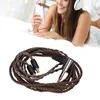 A woman is lying on a bed listening to music with headphones and a smartphone, with an audio cable in the foreground. Náhled obrázku produktu