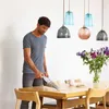 A man is vacuuming a table with a handheld vacuum cleaner. Anteprima dell’immagine prodotto