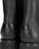 A close-up view of the back of two black leather boots, showing the brand logo on a patch. Produktbild-Vorschau
