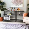 A modern living room scene featuring a black metal console table with books and decorative items. Produktbild-Vorschau