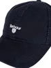 A close-up studio shot of a navy blue baseball cap with the Barbour logo embroidered on the front. Produktbild-Vorschau