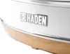 A close-up shot of the base of a white kettle with a silver logo and a wooden accent. Produktbild-Vorschau