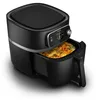 A black Philips air fryer with a dish of food inside, shown from a slightly elevated side angle. Podgląd zdjęcia produktu