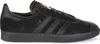 A black Adidas Gazelle sneaker shown from the side against a white background. Voir les images du produit