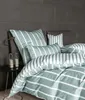 A neatly made bed with striped bedding and pillows against a dark tiled wall. Produktbild-Vorschau