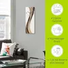 A clock on a wall above a sofa in a living room, with marketing icons on the right. Produktbild-Vorschau