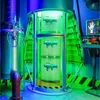 A futuristic laboratory setting with three ray guns displayed vertically in a glowing green cylindrical chamber. Náhled obrázku produktu