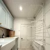 A laundry room with a sink, cabinets, a door, and a wall-mounted drying rack. Produktbild-Vorschau