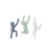 Three small figures in blue, green, and white, appearing to climb or hang. Náhled obrázku produktu