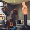 A man is practicing martial arts in a living room with a punching dummy. Podgląd zdjęcia produktu