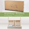 A cardboard box with grass illustration and product information, followed by a disassembled wooden garden bench. Anteprima dell’immagine prodotto