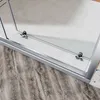 A close-up view of a shower door's sliding mechanism and bottom track, showing the rollers and frame against a light gray floor. Podgląd zdjęcia produktu