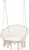 A white macrame hammock chair with a cushion, suspended by ropes.