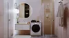 A modern bathroom with a washing machine, vanity, mirror, and shower. Produktbild-Vorschau
