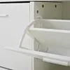 Close-up view of an open white shoe cabinet with a tilting drawer mechanism. Produktbild-Vorschau