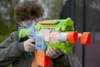 A young person holding a Nerf gun outdoors. Produktbild-Vorschau