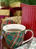 A festive Christmas scene with a mug of tea, gifts, and a pitcher. Produktbild-Vorschau